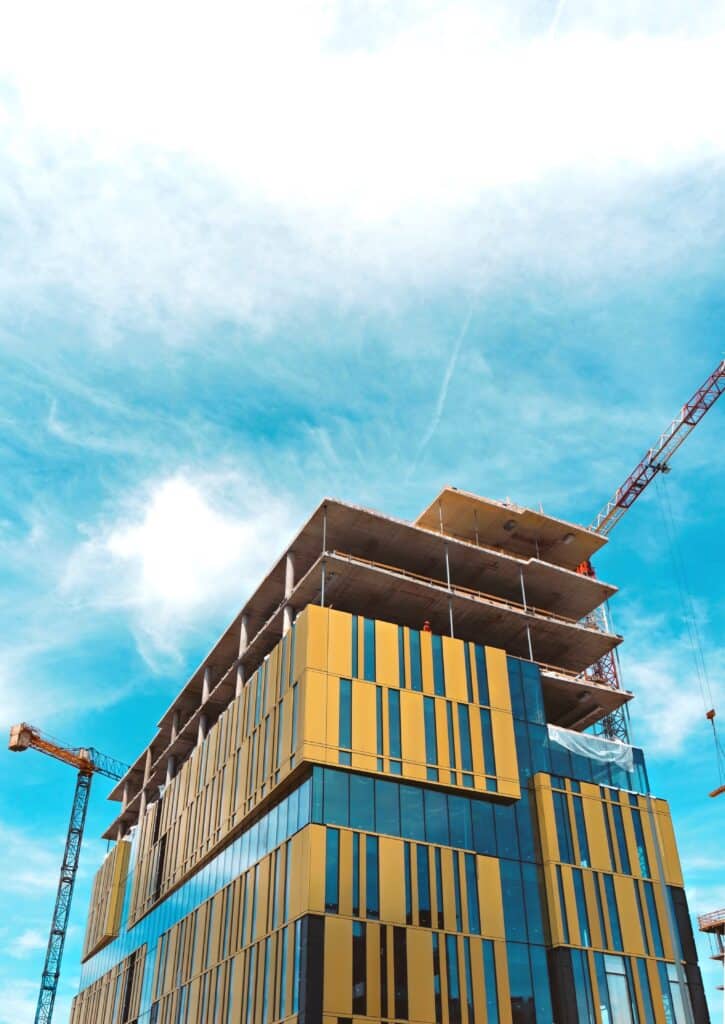 Immeuble moderne en construction avec ciel bleu.